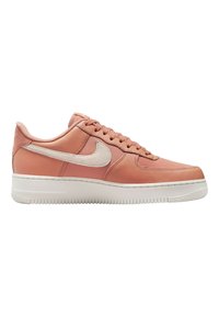Nike Air Force 1 sneakers med en slät rosa läderöverdel, vita accenter och texturerad gummisula. Klassisk snörningsdesign.