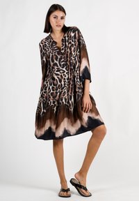 Leopardenmuster-Kleid mit V-Ausschnitt, fließender Silhouette und Dreiviertelärmeln. Besitzt einen Farbverlauf in Brauntönen und schwarzen Farbtönen.