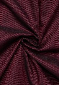 Getextureerde stof met een diepe bordeauxrode kleur, een geometrisch ruitpatroon en een lichte glans, weergegeven in een cirkelvormige plooi.