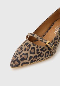 Leopardo-kuosi tasapohjaiset kengät, joissa on terävä kärki, valmistettu teksturoidusta kankaasta, ja joissa on yksi hihna sekä kultainen solkiyksityiskohta. Vaaleanruskea pohja.