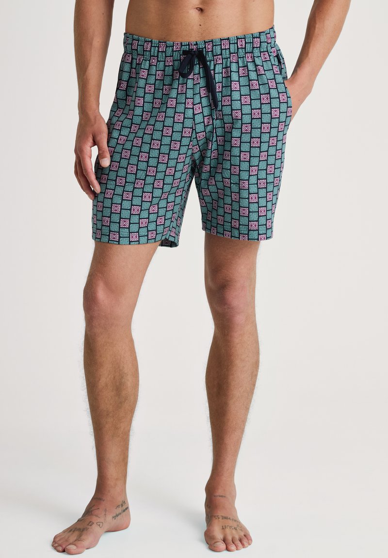 Zwemshorts van lichtgewicht stof met een turquoise achtergrond en een geometrisch patroon in roze en paars, elastische tailleband met een trekkoord.