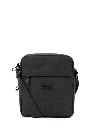 Petit sac bandoulière en tissu noir avec poche avant zippée, sangle réglable et patch logo Fagola visible centré sur le devant.