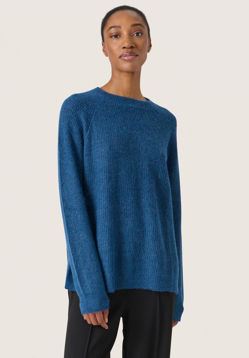Maglione blu in maglia con vestibilità morbida, scollatura a girocollo, spacchi laterali e maniche lunghe. Texture morbida con un sottile motivo a coste.