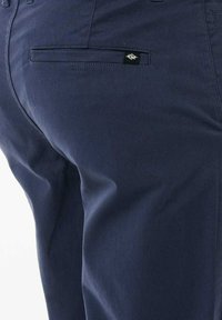 Pantaloni blu navy realizzati in morbido cotone, dotati di una tasca posteriore con un piccolo etichetta nera e dettagli di cucitura discreti.