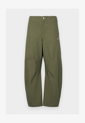 Olive zielone spodnie o szerokich nogawkach z zapięciem na guziki i subtelnym białym logo Nike na prawej udzie, prezentowane na jednolitym tle.