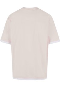 Kortærmet T-shirt i lyserød bomuld med rund hals. Har kontrasterende hvide detaljer ved ærmerne og nederste kant.