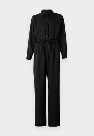 Fekete hosszúujjú kezeslábas, gombos elülső résszel, mellzsebbel, elasztikus derékkal húzózsinórral, és széles lábakkal, sima anyagból.