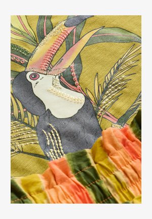 Il tessuto ricamato presenta un design di tucano con colori vivaci, tra cui verdi, gialli e rosa, e un orlo multicolore arricciato.