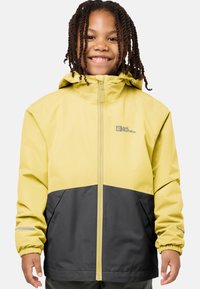 Veste imperméable jaune et grise avec capuche, fermeture éclair, poignets élastiques et accents réfléchissants. Fabriquée en tissu durable et respirant.