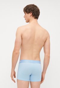 Boxeri de culoare albastru deschis, dintr-un material moale și elastic. Au un elastic cu marcă și un design ajustat.