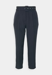 Granatowe spodnie z pasem na guziku, z wieloma pętelkami na pasek. Zwężane nogawki z fałdami z przodu, gładka tekstura.