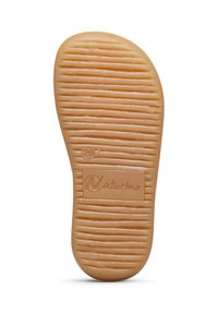 Suela de goma de color marrón claro, con surcos horizontales y una superficie texturizada. Incluye una etiqueta con el logo de "Naturino".