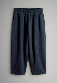 Navy blue, lightweight pants with an elastic waistband, cropped length, smooth texture, and decorative stitching along the side seams.