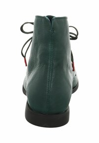 Stivale alla caviglia in pelle verde con punta arrotondata, suola nera piatta e lacci rossi legati sul retro. Texture liscia con dettagli minimi.