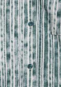 Grön och vit randig skjorta i mjuk textil; har en framträdande knapp och en ficka på vänster sida.