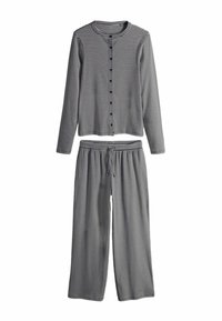 Conjunto de pijama a rayas que incluye una camisa de manga larga con botones y pantalones de pierna ancha con cintura elástica en colores azul marino y blanco. Textura de tela suave.