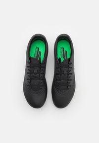 Czarne buty sportowe z teksturowaną cholewką, okrągłym noskiem i systemem sznurowania; zielona wkładka z czarnym logo; gładka gumowa podeszwa.
