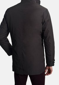 Men's black insulated jacket, featuring a high collar, seamless design, side pockets, and adjustable cuffs. Smooth texture with subtle sheen.
