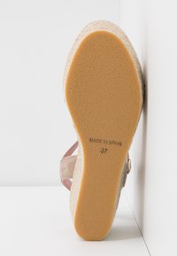 Semelle de sandale compensée en caoutchouc marron clair taille 37 avec le texte "Made in Spain", plateforme beige tissée et bride en daim rose.