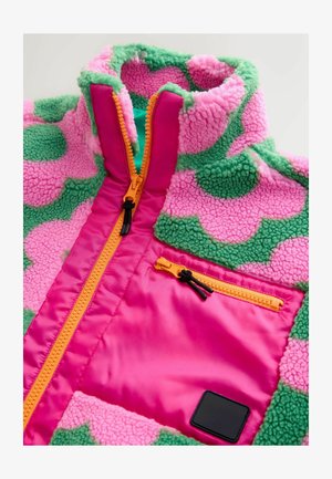Fleecejakke med pink og grøn farveblokdesign. Har en høj krave, orange lynlås og en frontlomme med sort detalje. Blød tekstur.