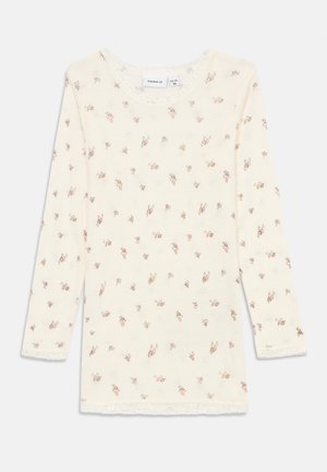 Crèmekleurig shirt met lange mouwen met kleine roze en bruine bloemenprint, kanten rand bij de halslijn en manchetten, platgelegd op witte achtergrond.