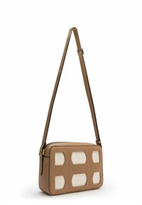 Sac bandoulière en cuir marron, à la forme rectangulaire, avec des accents découpés couleur crème et une sangle plate réglable. Fermeture éclair sur le dessus.