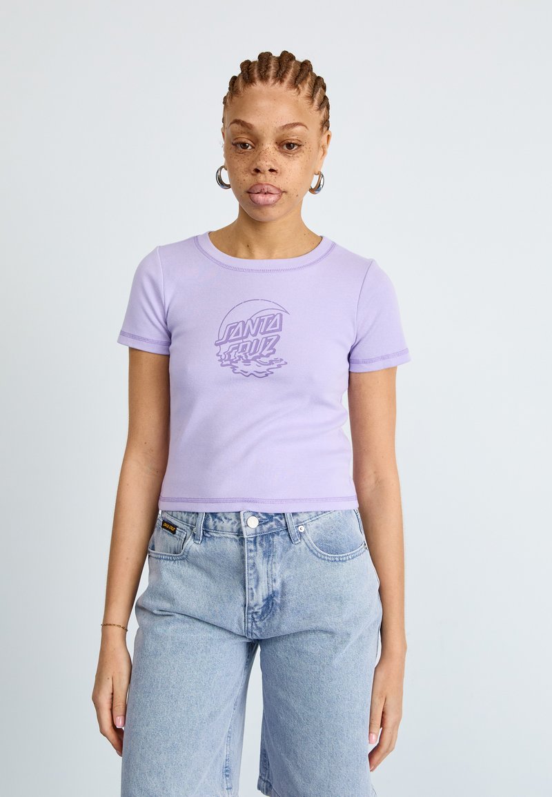 Lilac cropped t-shirt with a round neck, short sleeves, and a printed "Santa Cruz" logo in darker purple, paired with light blue denim shorts.