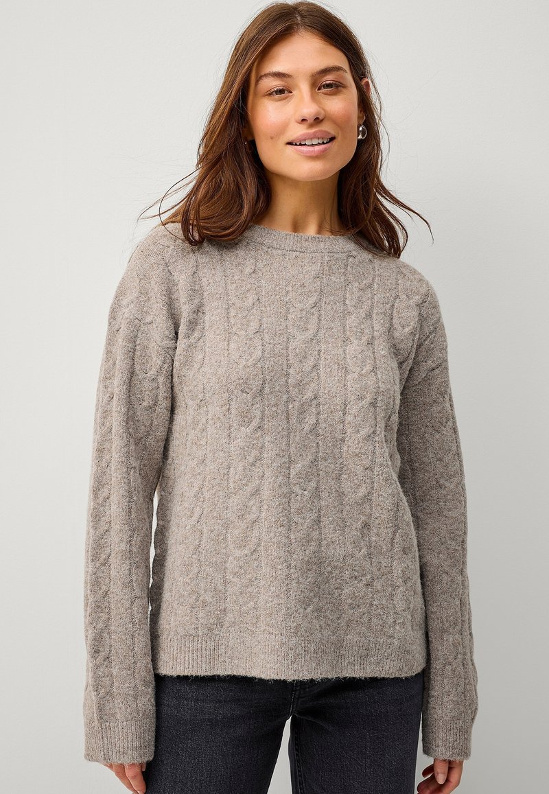 Lys grå strikket sweater med et struktureret kabelmønster, rund hals og ribkant. Lange ærmer med brede manchetter.