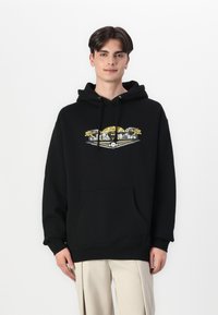 Black hooded sweatshirt with a front pocket, featuring a colorful graphic design of a landscape with architectural elements and accents.