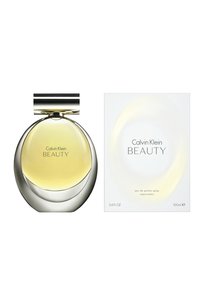 Calvin Klein Beauty-parfym i en rund glasflaska med silverlock, som innehåller gul vätska, bredvid en enkel vit låda med produktinformation.