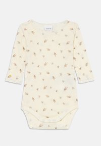 Langermet baby body i kremfarget bomull, med blomstermønster og blondekant ved halsen og mansjettene. Trykknapper i bunnen.