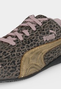 Sneaker Puma με λεοπάρ σχέδιο, ροζ κορδόνια και λογότυπο, με χρυσή σουέντ πλευρική ρίγα και μαύρη σόλα.