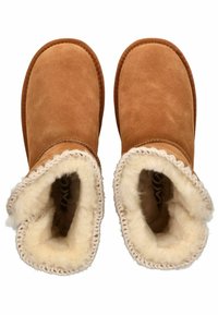 Brune ruskinds støvler med en blød, cremet fåreskindsforing. Kantet med en vævet beige trim. U-formede åbninger for nem påføring.
