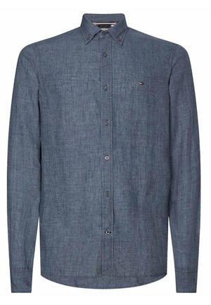 Chemise manches longues à boutons en tissu bleu foncé texturé avec un petit logo sur la poitrine gauche et un col boutonné.