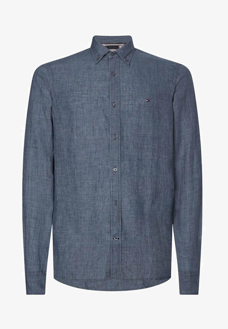 Chemise manches longues à boutons en tissu bleu foncé texturé avec un petit logo sur la poitrine gauche et un col boutonné.