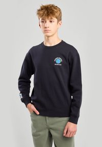 Musta puuvillane sweatshirt, millel on ümar kaelus, kaunistatud värvikate maapinna graafika ja tekstiga rinnal. Ribidega mansetid ja allääre. Laias lõikes.