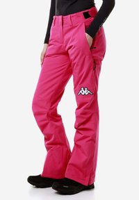 Pantaloni da sci rosa realizzati in materiale impermeabile, con zip frontale, tasche laterali, passanti per cintura e logo Kappa sulla coscia sinistra.