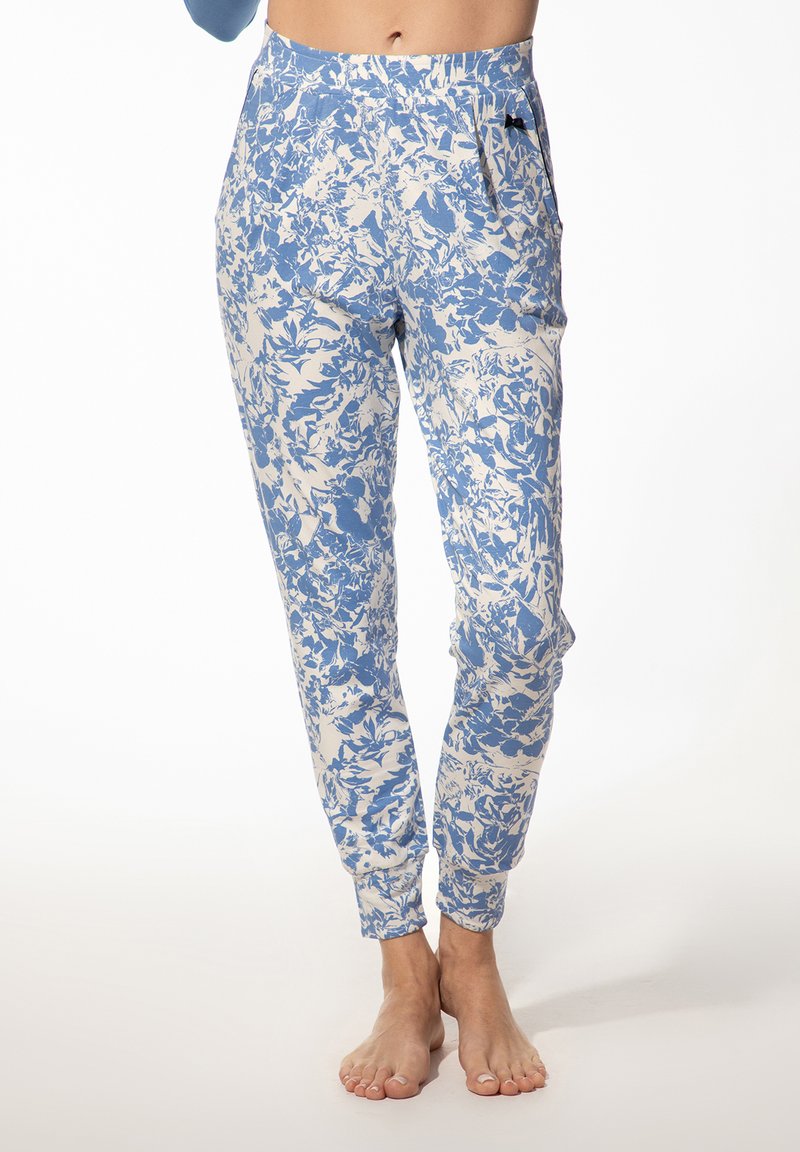 Lichte bloemen joggers in blauw en crème, met een elastische tailleband, zijzakken en taps toelopende boorden. Zachte stof met een subtiel patroon.