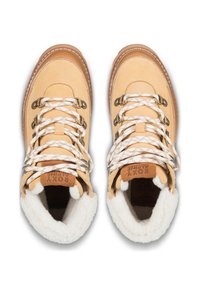 Tan wandelschoenen met een zachte crèmekleurige voering, witte en tan veter, metalen oogjes en een gestructureerde zool. Logo zichtbaar op de tong.