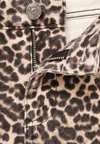 Tessuto con stampa leopardata su sfondo beige, caratterizzato da una cerniera argentata e una chiusura con bottone. Texture con macchie marroni scure e dettagli di cucitura.