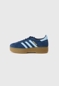 Tênis de camurça azul-marinho com riscas azul claro, biqueira redonda e sola em borracha cor de goma. Logótipo dourado "Spezial" na lateral, design clássico da Adidas.