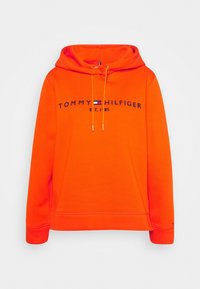 Oranje hoodie gemaakt van zachte stof met een capuchon met trekkoord, een voorzak en een geborduurd "TOMMY HILFIGER" logo met blauwe accenten.