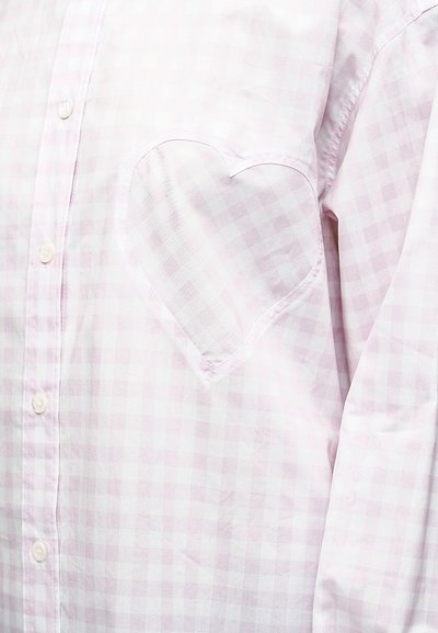 Πουκάμισο μακρυμάνικο ροζ ανοιχτό και λευκό καρό με τσέπη στην περιοχή του στήθους σε σχήμα καρδιάς και λευκά κουμπιά στο μπροστινό μέρος.