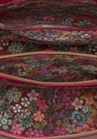 Floral-patterned fabric zip pouch with a dark brown background, gold zipper, and vibrant pink accents, featuring multiple compartments.