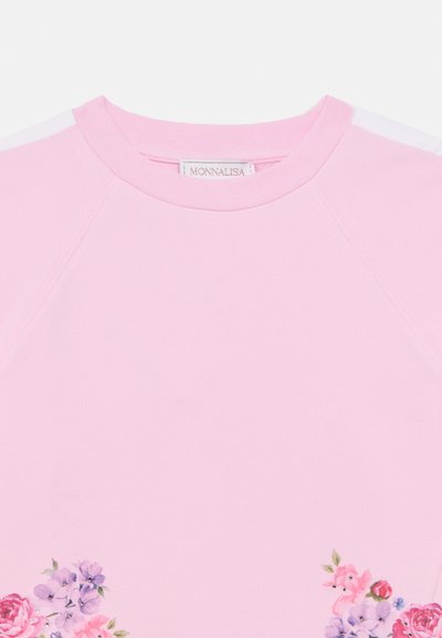 Ροζ βαμβακερό T-shirt με ραγκλάν μανίκια, διακοσμημένο με λουλουδάτο σχέδιο στο κάτω αριστερό μέρος. Λευκές λεπτομέρειες στους ώμους και στη λαιμόκοψη.