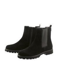 Bottines en daim noir avec fermeture éclair latérale, panneau élastique, languette de tirage, détails de brogue sur le bout et semelle en caoutchouc épaisse.
