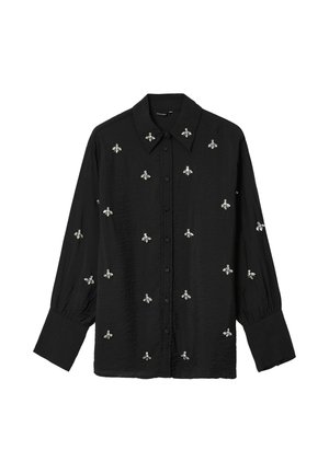Camicetta nera con colletto, decorata con ricami di api argentate su tutto il tessuto. Realizzata in tessuto leggero, con maniche lunghe e polsini arricciati.