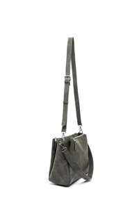 Harmaa nahkalaukku, jossa on säädettävät olkahihnat ja hopeiset vetoketjut, esiteltynä roikkumassa valkoista taustaa vasten.