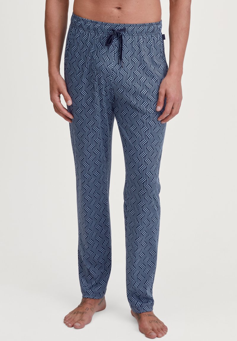 Marineblauwe pyjamabroek met een geometrisch wit patroon. Gemaakt van zacht materiaal, met een elastische tailleband met een trekkoord en rechte pijpen.