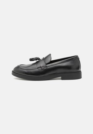 Mustad nahast loafers-tüüpi kingad sileda pinnaga, mille esiküljel on dekoratiivne sõlme ja madal, tekstuuriga kummist tall.